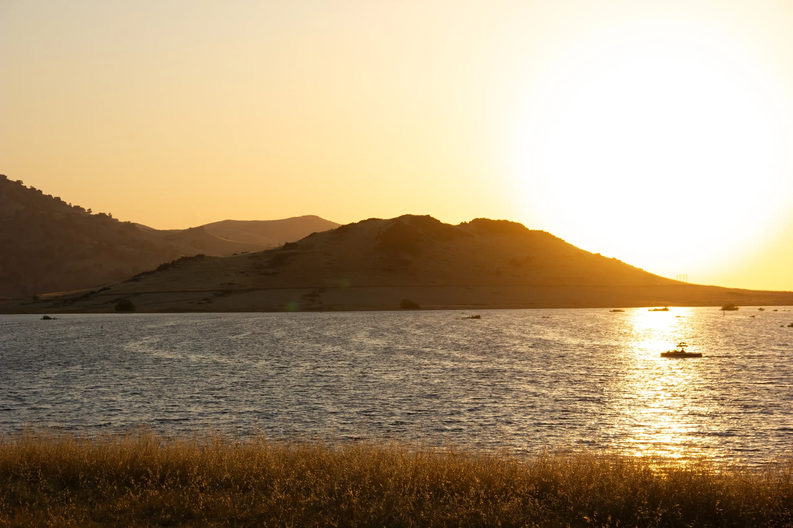 Sunset on a lake with a boat.